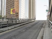 a view of the empty street with several arrows painted on it and tall buildings in the background