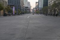 empty street with tall buildings and a yellow fire hydrant in the center of the image