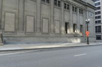 a picture of an empty street in front of the office building that is built on a corner