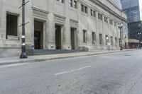 a picture of an empty street in front of the office building that is built on a corner