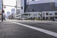 an empty street with cars, buildings, and traffic signals in the background and the sun shines bright