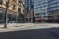 empty street with people walking on it in the middle of city area of town and two tall skyscrapers