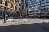 empty street with people walking on it in the middle of city area of town and two tall skyscrapers