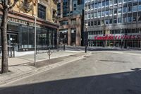 empty street with people walking on it in the middle of city area of town and two tall skyscrapers