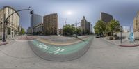 the view of an empty street from inside a fisheye lense, and an image of a city