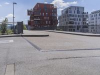 an empty street in front of apartment buildings and a bridge with a railing leading to it