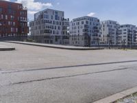 an empty street in front of apartment buildings and a bridge with a railing leading to it