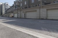 an empty street next to a large garage building with a sign out front that says west side