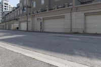 an empty street next to a large garage building with a sign out front that says west side