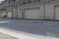 an empty street next to a large garage building with a sign out front that says west side