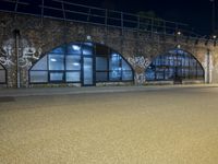 an empty street with graffiti and night sky in background from the corner of a road