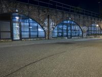 an empty street with graffiti and night sky in background from the corner of a road