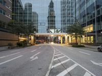 the empty street in the city is empty with buildings around it, and a tower in the distance