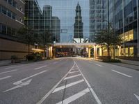 the empty street in the city is empty with buildings around it, and a tower in the distance