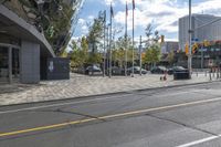 an empty street at an intersection of a street in front of large buildings with glass windows