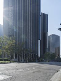 a person walking down a deserted city street with skyscrapers in the background in the daytime