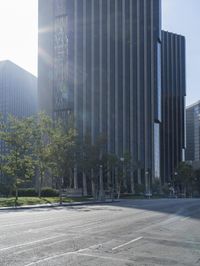 a person walking down a deserted city street with skyscrapers in the background in the daytime