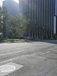 a person walking down a deserted city street with skyscrapers in the background in the daytime