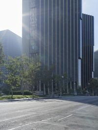 a person walking down a deserted city street with skyscrapers in the background in the daytime