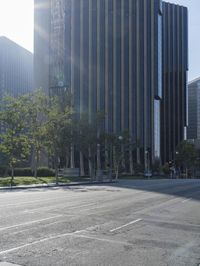 a person walking down a deserted city street with skyscrapers in the background in the daytime