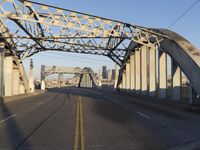 an image of an empty street in a city setting with a bridge in the background