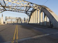 an image of an empty street in a city setting with a bridge in the background