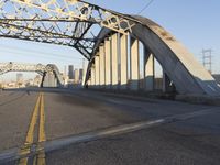 an image of an empty street in a city setting with a bridge in the background