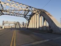 an image of an empty street in a city setting with a bridge in the background