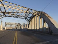 an image of an empty street in a city setting with a bridge in the background