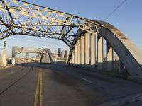 an image of an empty street in a city setting with a bridge in the background