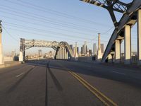 an image of an empty street in a city setting with a bridge in the background