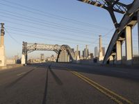 an image of an empty street in a city setting with a bridge in the background