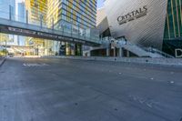 an empty street with several tall buildings in the background and a sign in the middle with an orange marker indicating