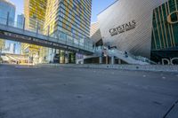 an empty street with several tall buildings in the background and a sign in the middle with an orange marker indicating