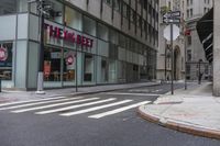 an empty city street with two tall buildings and a sign that reads nemo delect