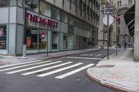 an empty city street with two tall buildings and a sign that reads nemo delect