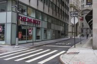 an empty city street with two tall buildings and a sign that reads nemo delect