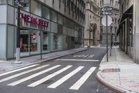 an empty city street with two tall buildings and a sign that reads nemo delect