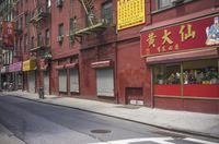 an empty street has a closed garage on the corner near an intersection with parked traffic