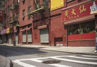 an empty street has a closed garage on the corner near an intersection with parked traffic