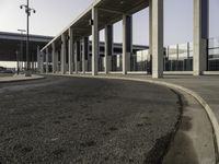 an empty street with parking spaces in the back and one is next to a big building