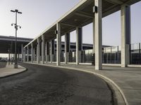 an empty street with parking spaces in the back and one is next to a big building