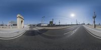 a 360 - angle shot of an empty street and the sun reflecting on it's horizon