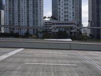 the empty street below the large buildings has no cars here and is gray and white