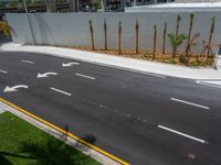 an empty street with many white arrows in it and grass on both sides of it