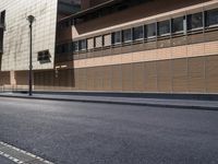 the side view of an empty street near a brick building with many windows on it