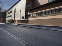 the side view of an empty street near a brick building with many windows on it