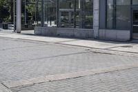 a person sitting at the bench in front of a mall that is empty of people