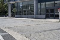 a person sitting at the bench in front of a mall that is empty of people