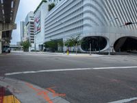 there is a empty street in front of some modern buildings and a bus stoplight